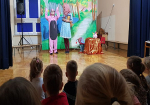 dzieci oglądają scenę z Alicja i różowym Królikiem w okularach